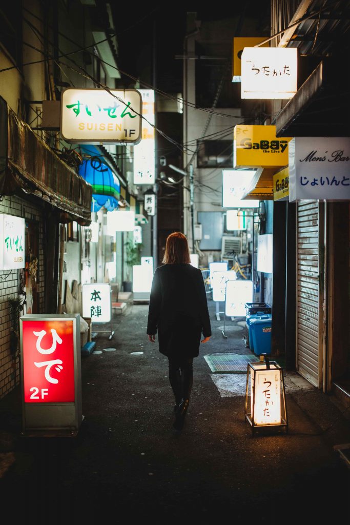 japonska ulica plna neonov so zenou v strede