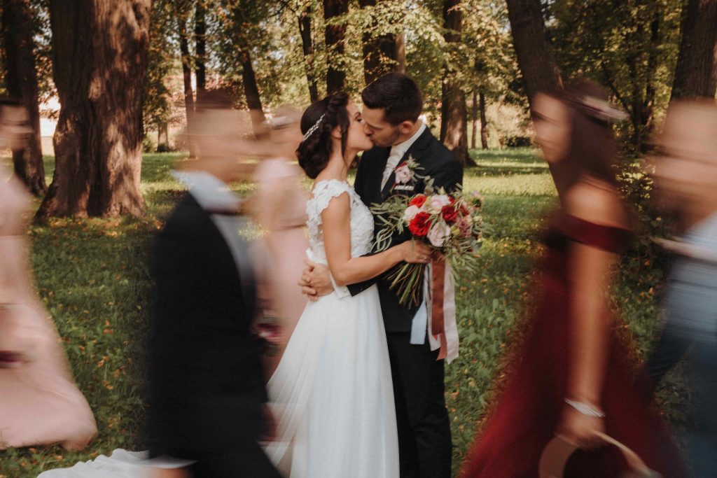 kreativna svadobna fotografia svadobneho paru medzi druzbami a druzickami odfotene pomocou motion blur efektu na dlhu uzavierku