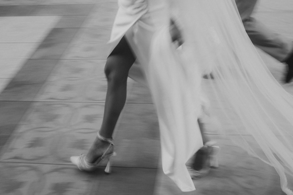 A woman in a wedding dress walking down the street.