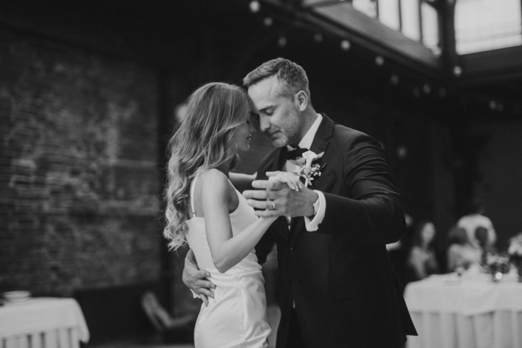 Black and white photo of bride and groom sharing their first dance.