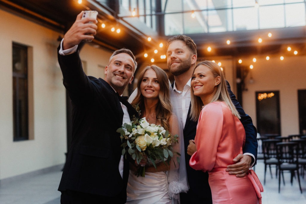A group of friends taking a selfie at a wedding venue.