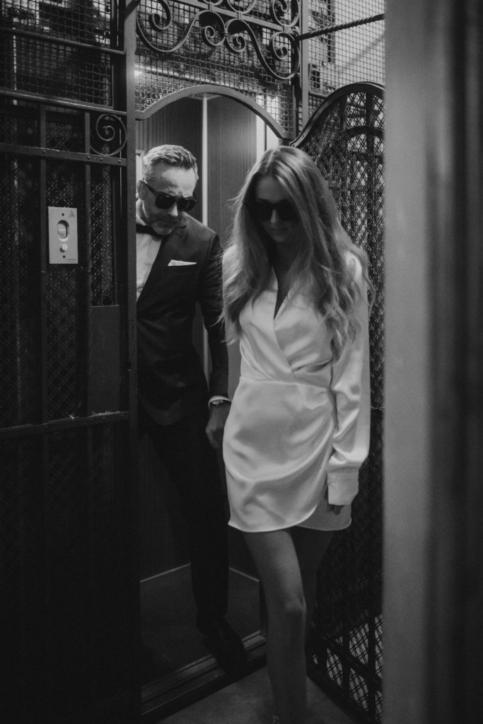 Stylish wedding couple in Rome exiting elevator in sunglasses
