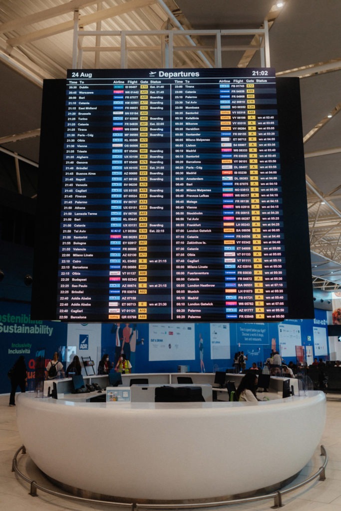A large screen showing flight information in an airport.