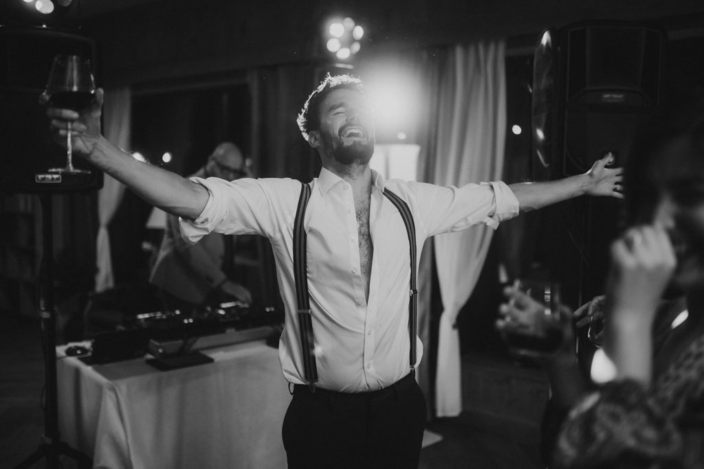 A man with his arms outstretched at a party.