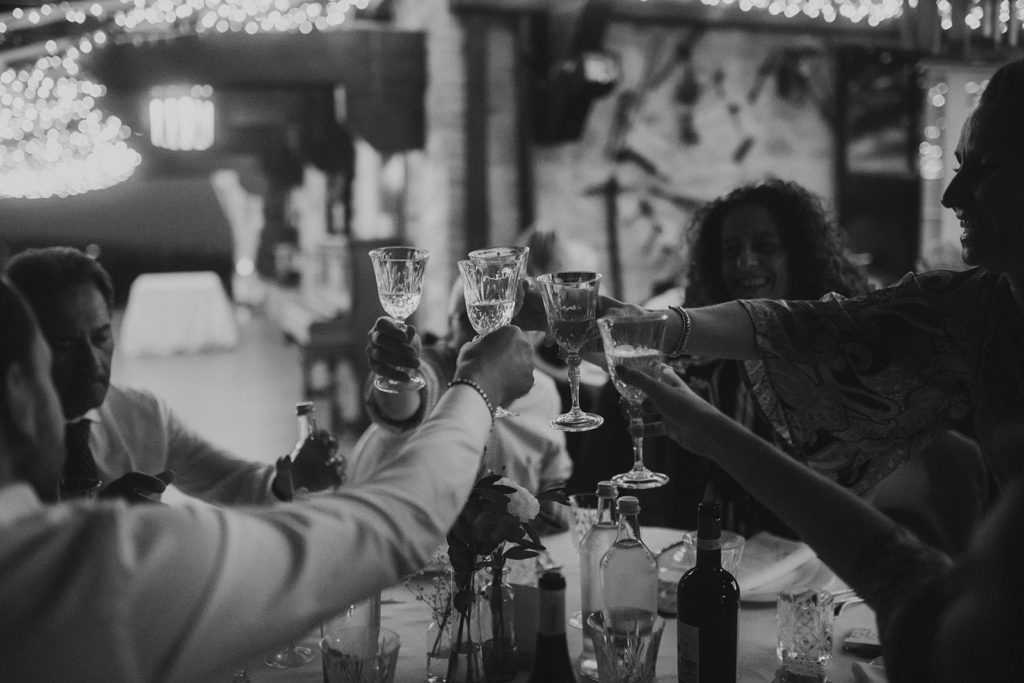 A black and white photo of people toasting at a table.