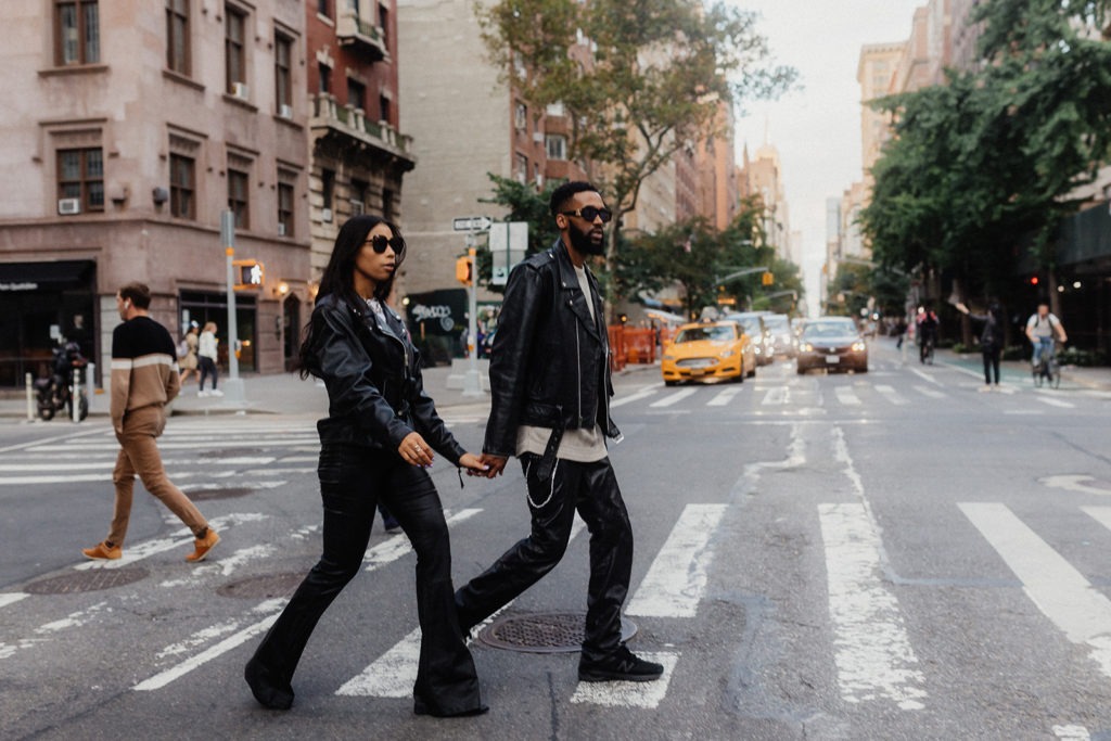 A man and woman walking across a street in nyc.