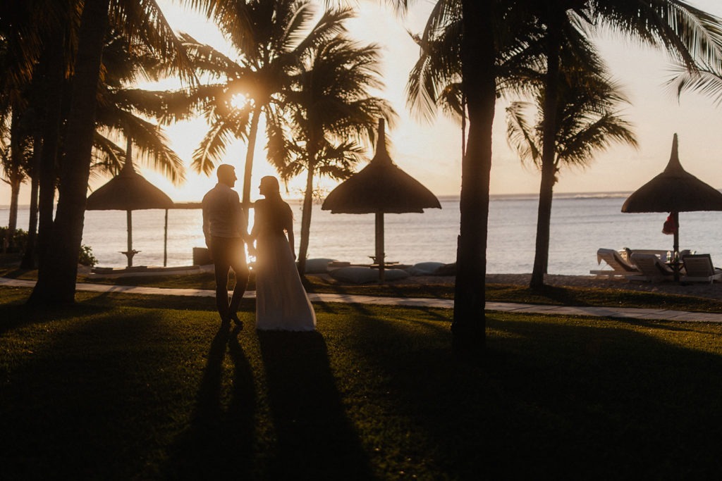 Wedding couple walking towards sunset in Mauritius beach at Lux Le Morne resort. Wedding