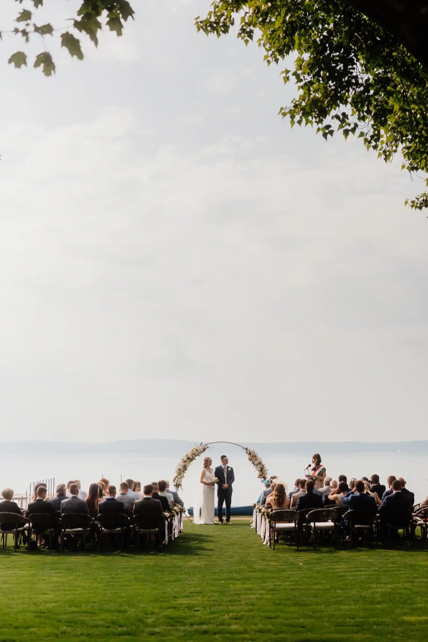 A wedding ceremony on the lawn overlooking the lake.