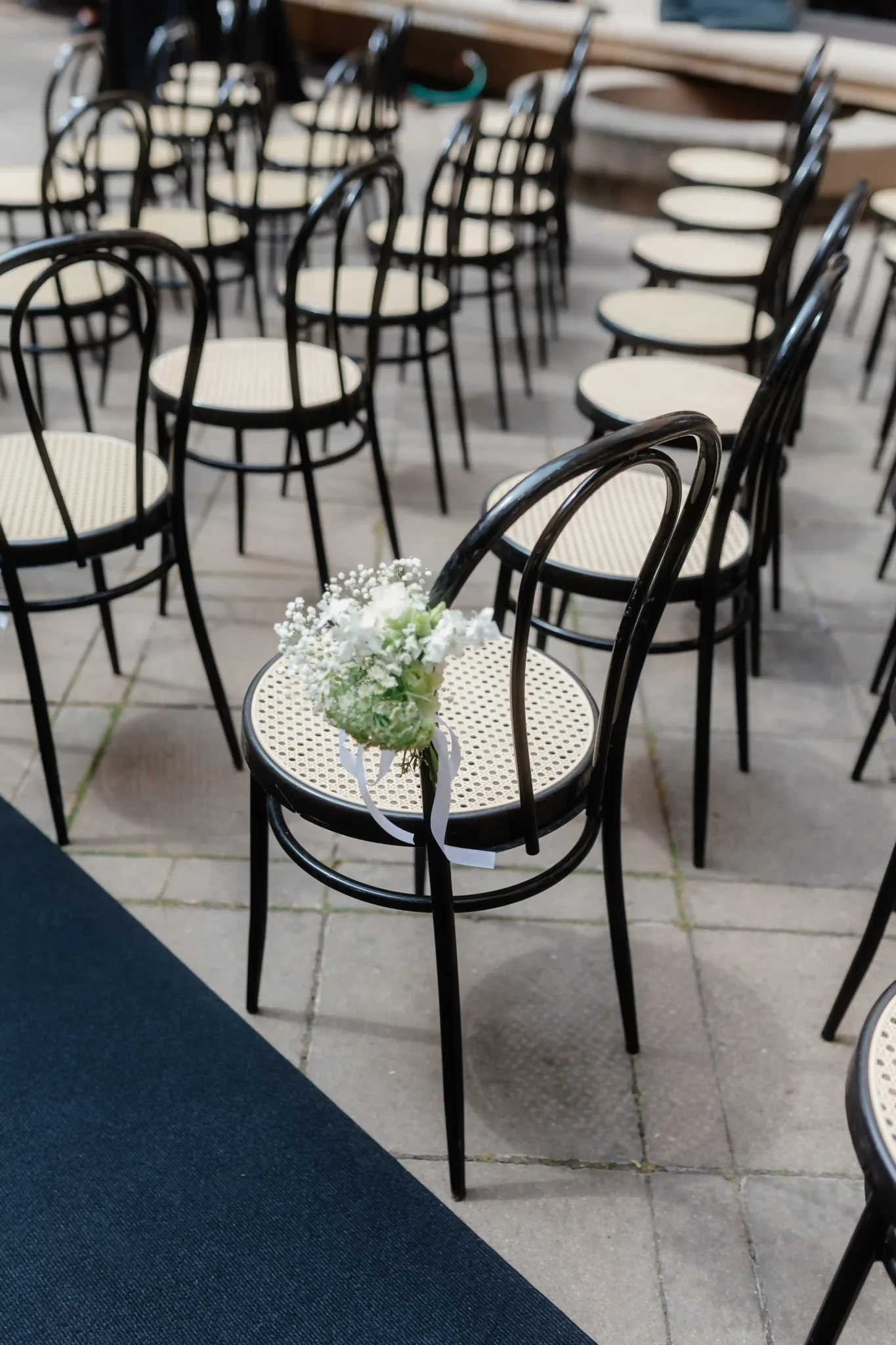 A row of black chairs with flowers on them.