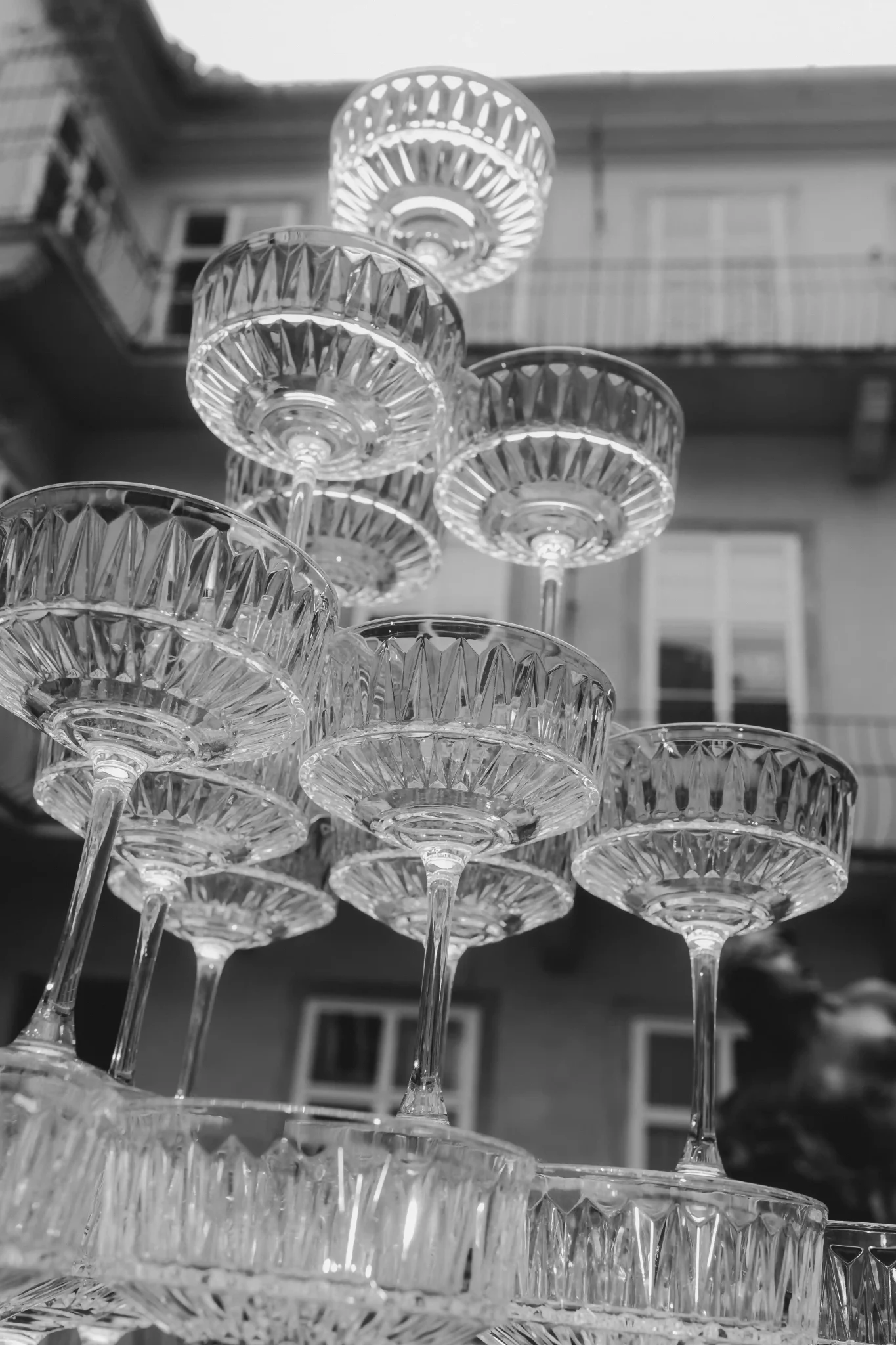 A stack of wine glasses on a table in front of a building.
