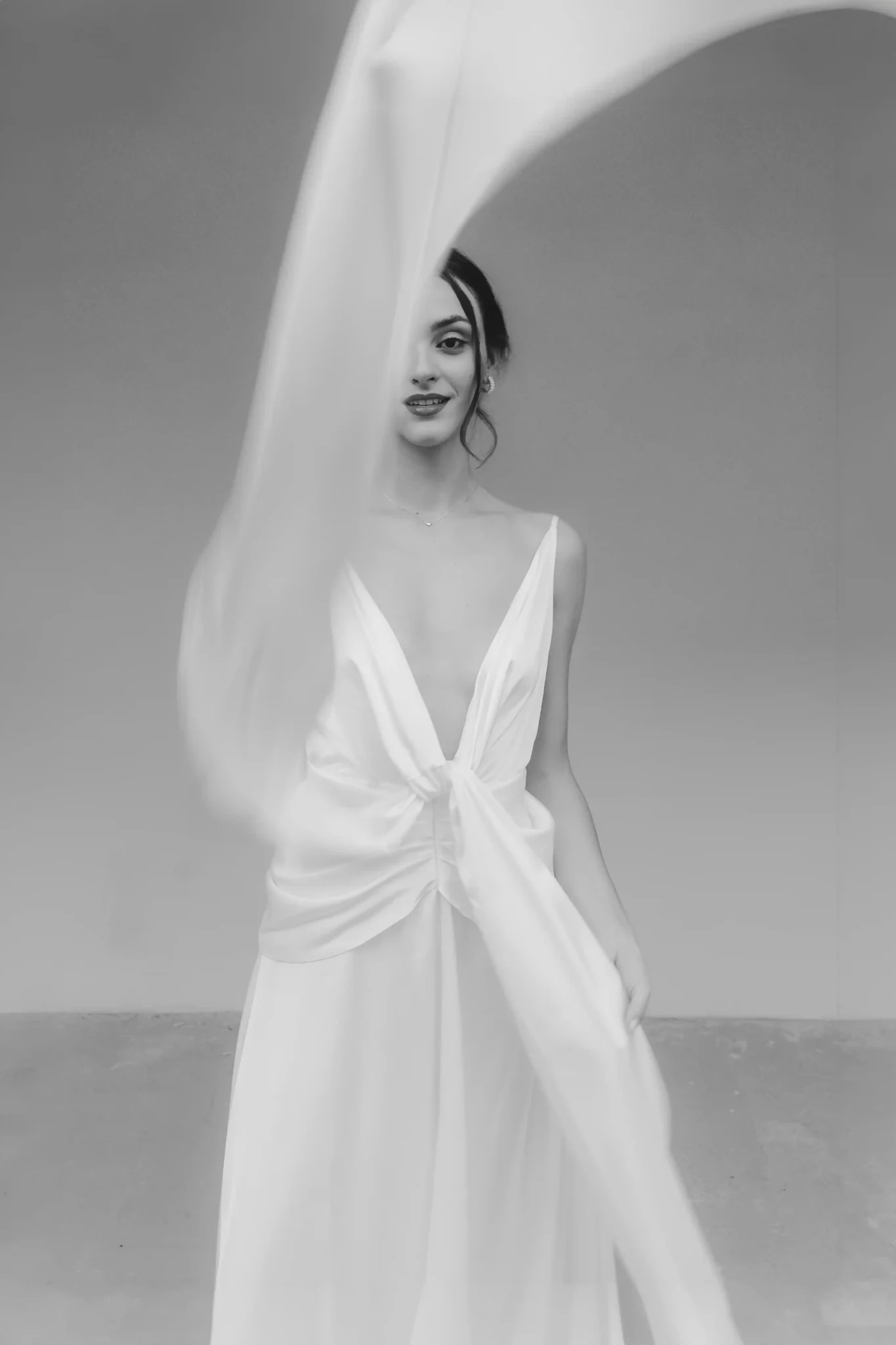 Creative editorial wedding photo of a bride with part of her wedding dress in motion