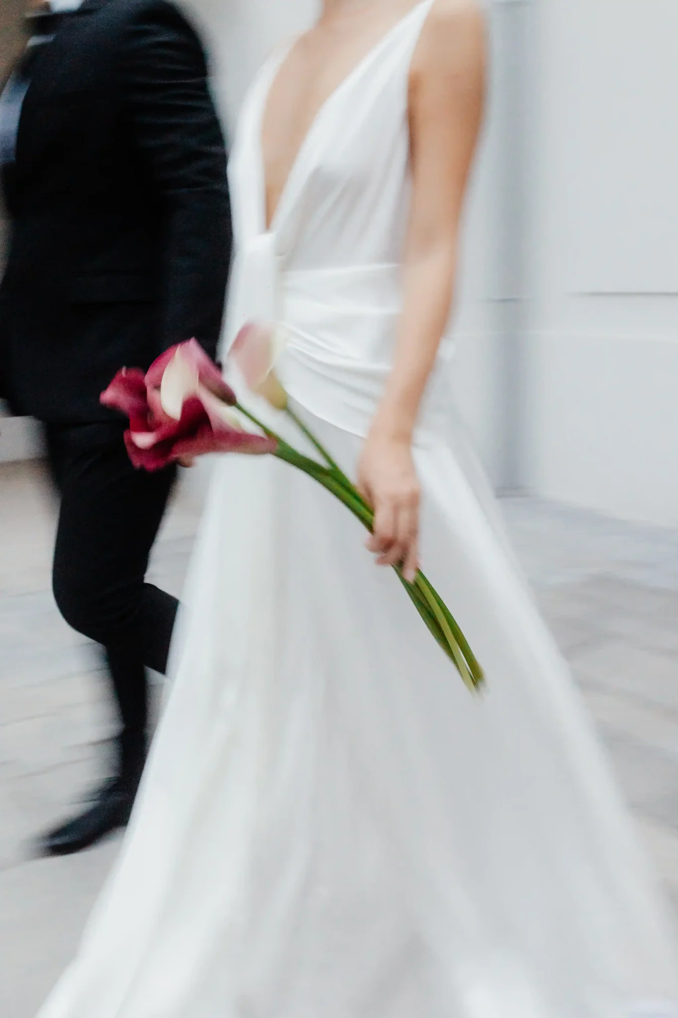 Detail shot of a wedding dress and flowers in motion