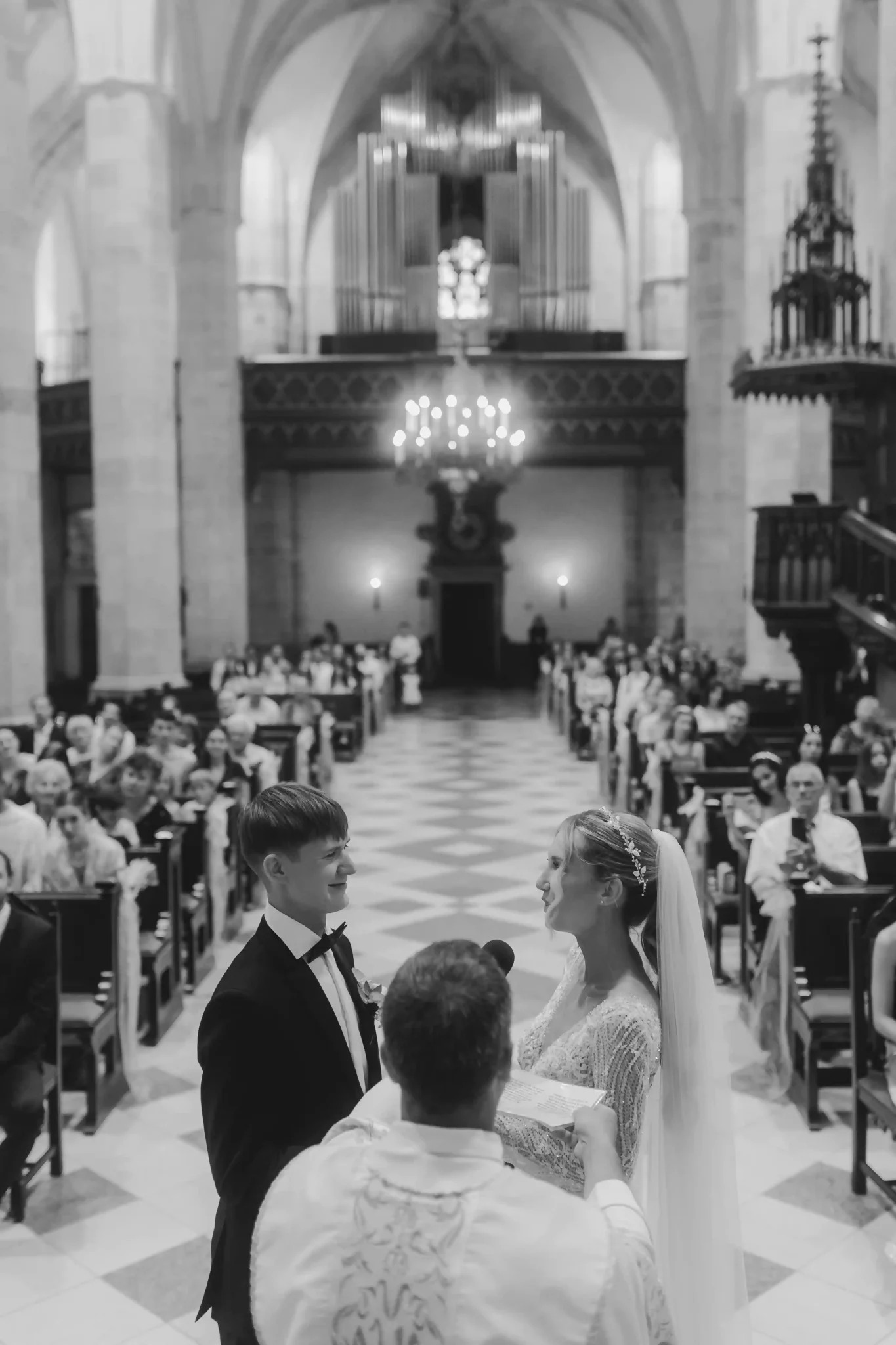A bride and groom exchange vows in a church.