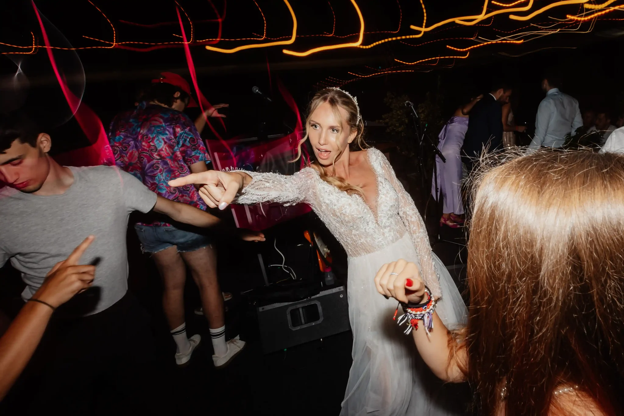 A bride dancing with her friends at a party.