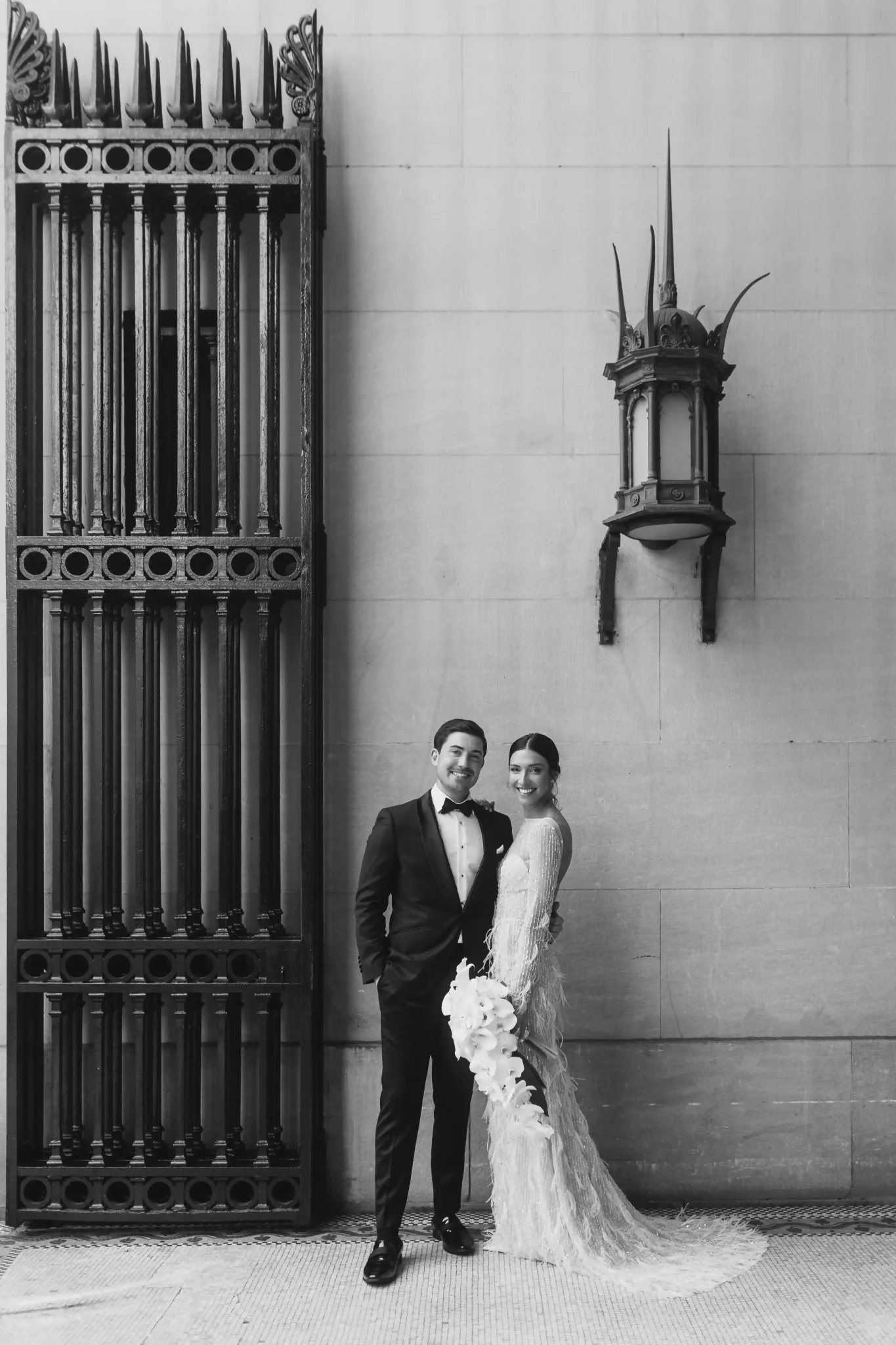 A bride and groom standing in front of an ornate door.