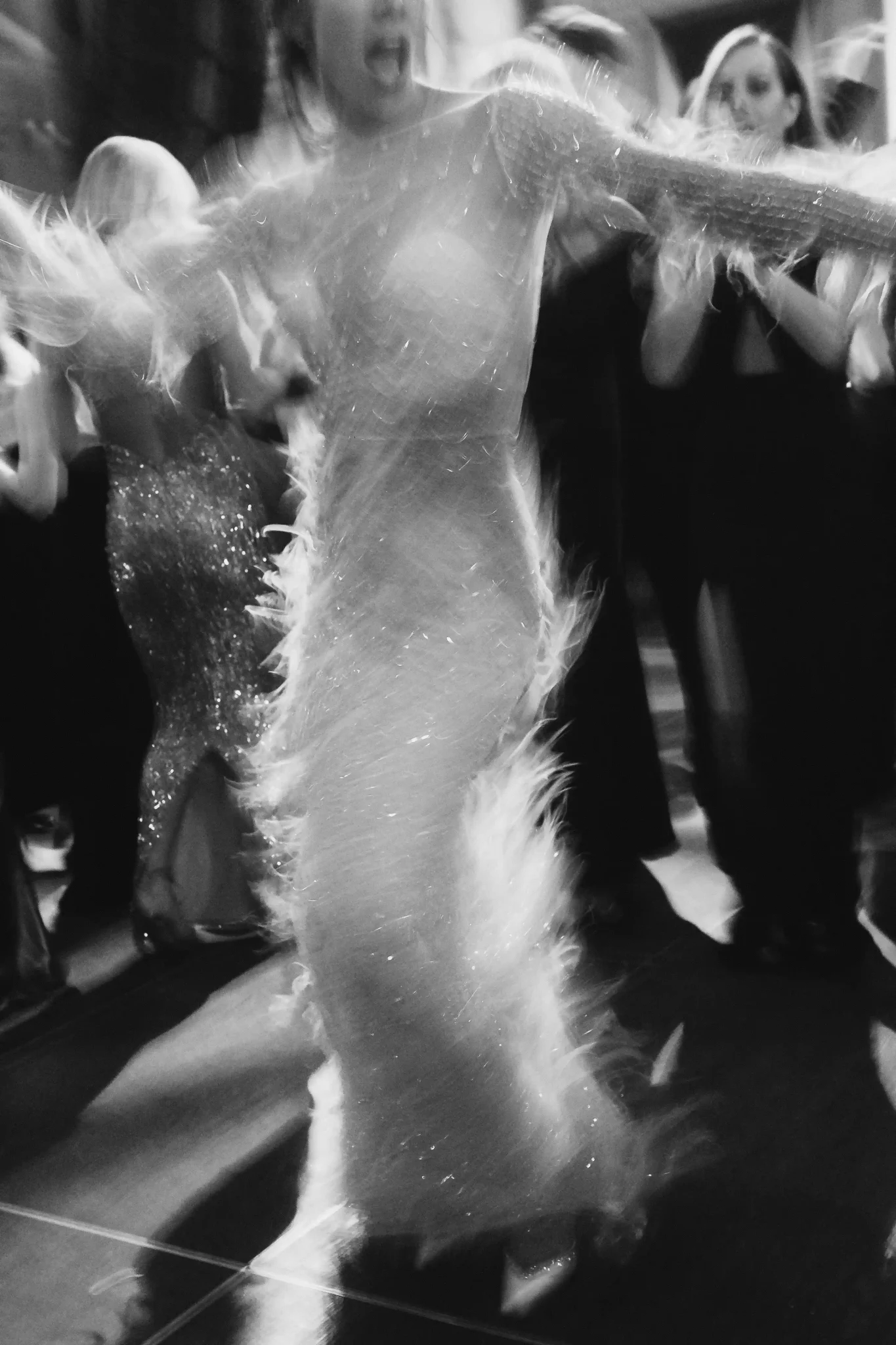 A woman in a white dress dancing at a wedding.